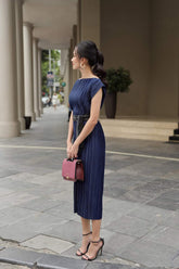 Pleated silk midi dress with boat neckline and waist-defining sash belt for elegant styling